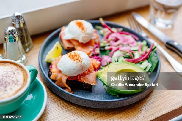 poached eggs with salmon and avocado on the plate, side view - food styling foto e immagini stock