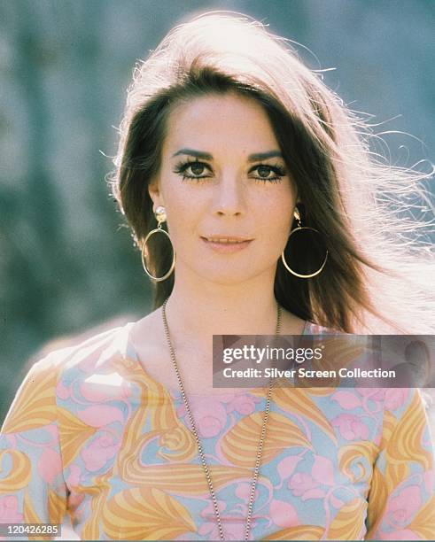Natalie Wood , US actress, wearing a print pattern top with a large gold necklace and gold hoop earrings, circa 1975.