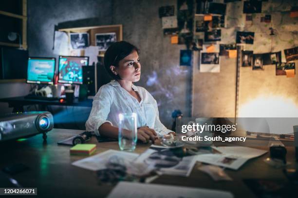 mujer policía trabajando hasta tarde - detective fotografías e imágenes de stock