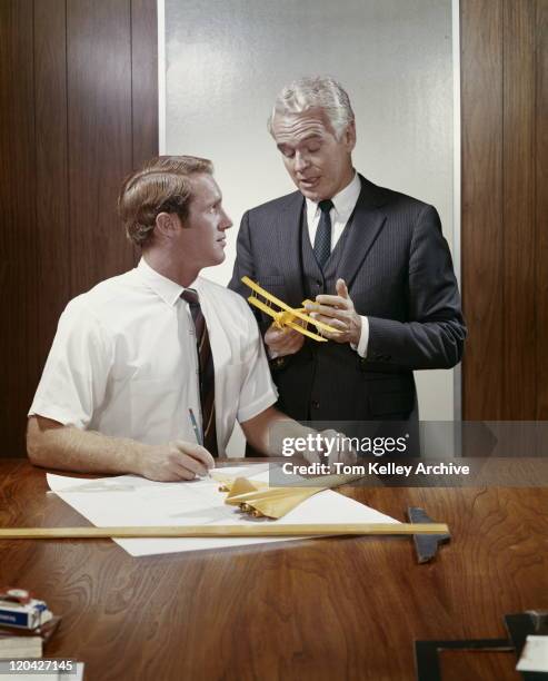 two businessmen with model aeroplane by table  - archival office stock pictures, royalty-free photos & images