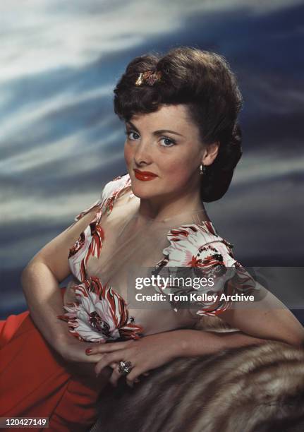 young woman leaning on rock, smiling, portrait - woman 1950 stock pictures, royalty-free photos & images