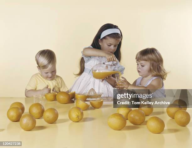 girl pouring orange juice in glass - orange juice stock pictures, royalty-free photos & images