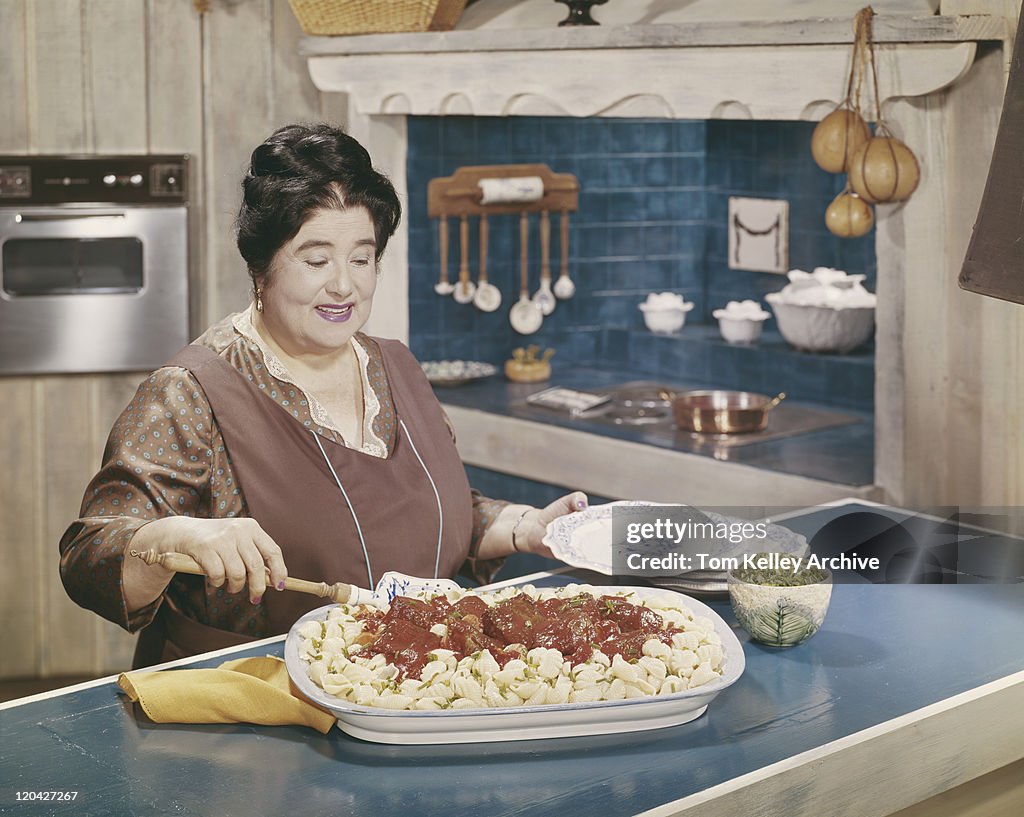 Femme préparant des plats de pâtes aux boulettes de viande en cuisine