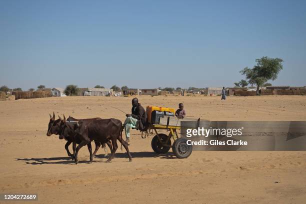 December 11, 2019. A refugee man and child transport water containers by cart and donkey in Awaradi Refugee camp in eastern Niger.