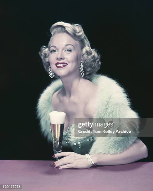 young woman holding glass of beer, smiling, portrait - archival alcohol stock pictures, royalty-free photos & images