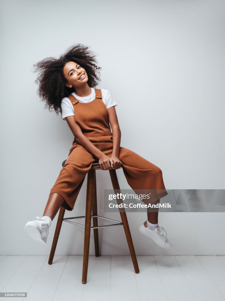 Belle fille de sourire avec la coiffure bouclée