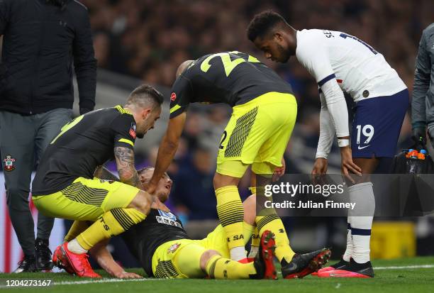 James Ward-Prowse of Southampton goes down injured and is checked on by his teammates and Ryan Sessegnon of Tottenham Hotspur during the FA Cup...