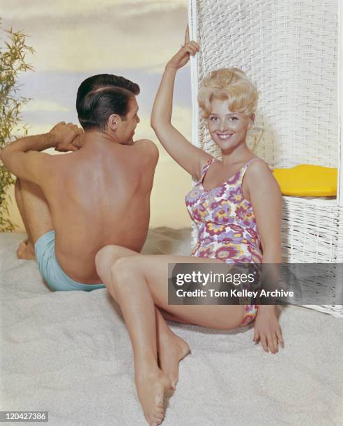 young woman leaning on swing chair beside man, smiling - 1962 bildbanksfoton och bilder