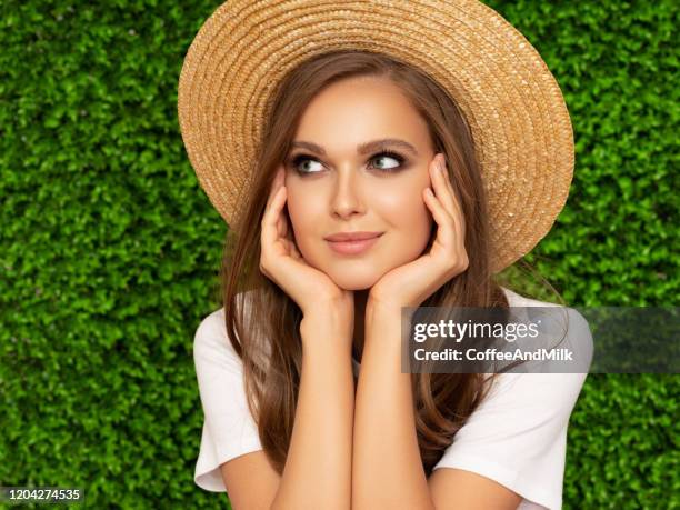 pretty girl in a hat on a green grass background - beautiful woman spring stock pictures, royalty-free photos & images