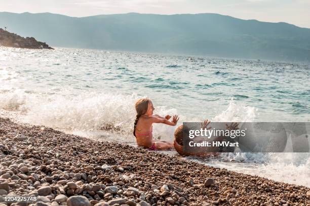 vrolijke vader en dochter op de zomervakantie genieten van spatten in de zee en spelen met golven - croatia coast stockfoto's en -beelden