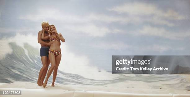 young couple standing on beach, smiling - historical romance stock pictures, royalty-free photos & images