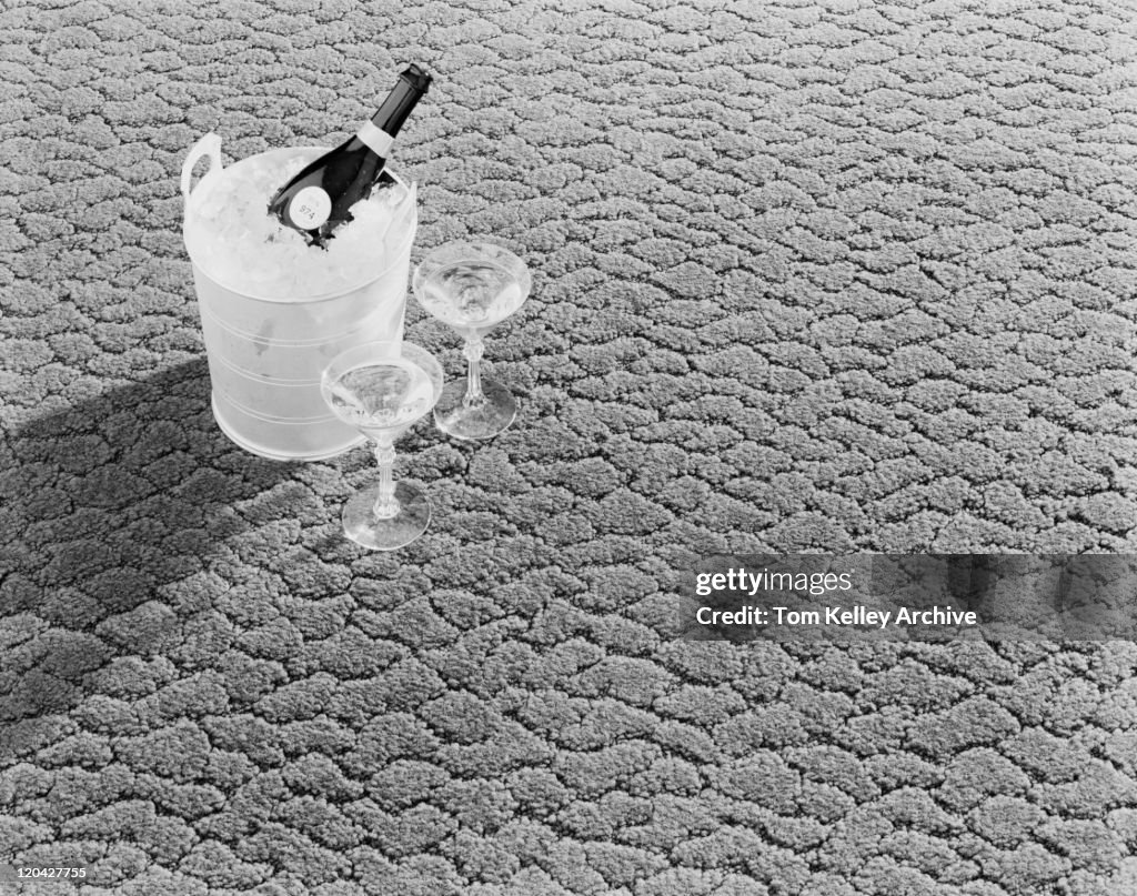 Champagne in ice bucket with glasses