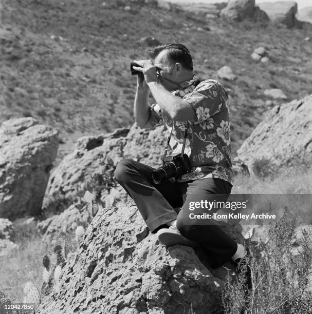 man sitting on rock with binoculars - binocular with man stock pictures, royalty-free photos & images