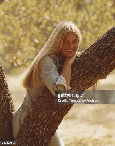 young woman leaning on tree, smiling - 1974 stock pictures, royalty-free photos & images