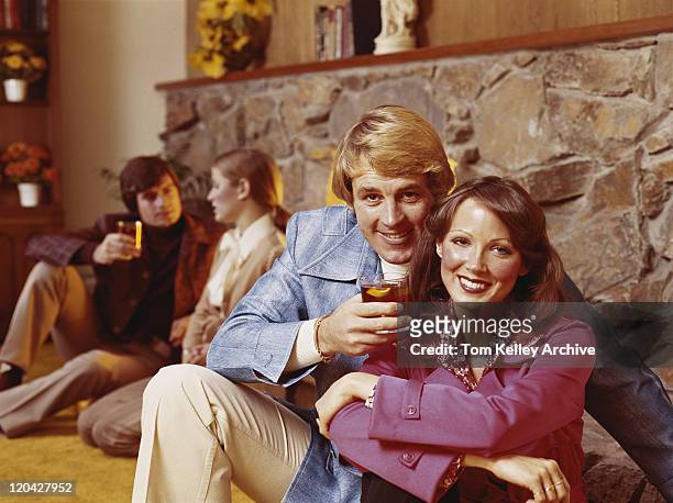 couples sitting by fireplace having drinks, smiling - 1975 個照片及圖片檔