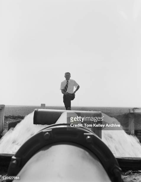 senior man standing on water pipe near sea - 1977 stock pictures, royalty-free photos & images