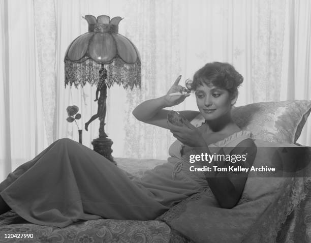 young woman tweezing eyebrows on bed - 1977 stock pictures, royalty-free photos & images