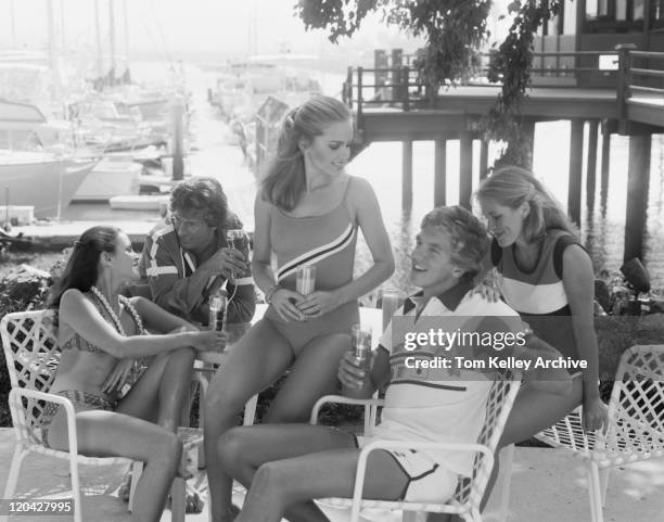 group of men and women relaxing at beach resort - 1977 stock pictures, royalty-free photos & images