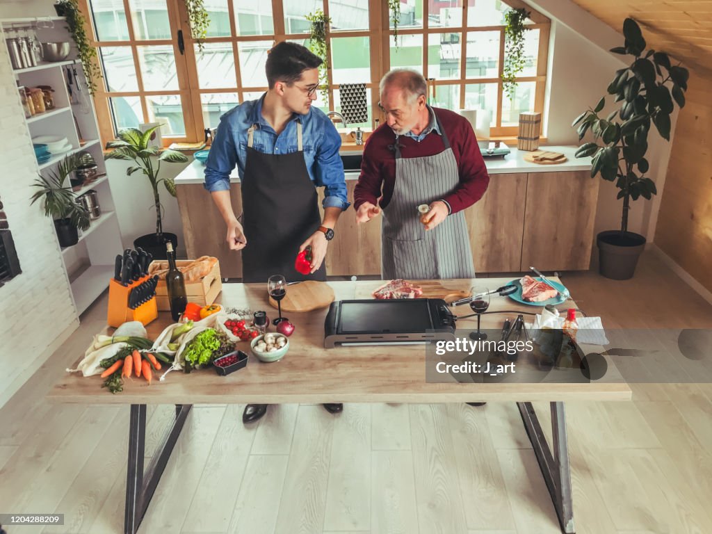 Father and son preparing food together