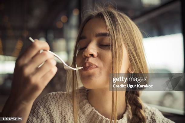 junge frau essen dessert - fork stock-fotos und bilder