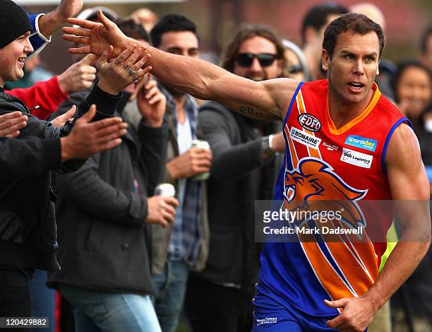 Wayne Carey playing for the Maribyrnong Lions high fives the crowd after snaping a goal during the Essendon Distrct Football League AFL match against...