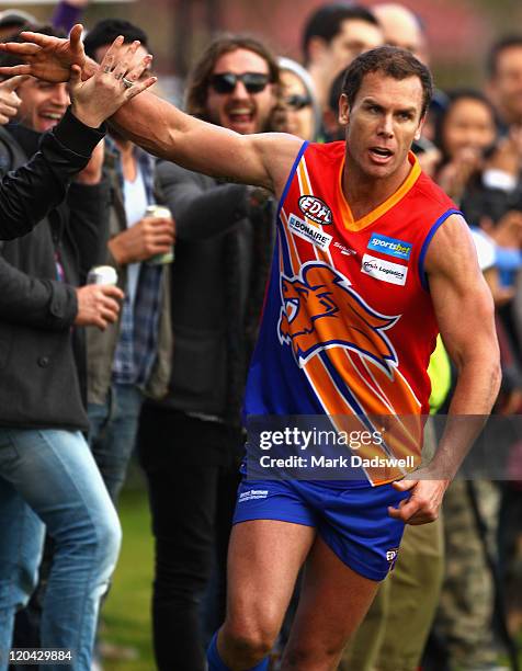 Wayne Carey playing for the Maribyrnong Lions high fives the crowd after snaping a goal during the Essendon Distrct Football League AFL match against...