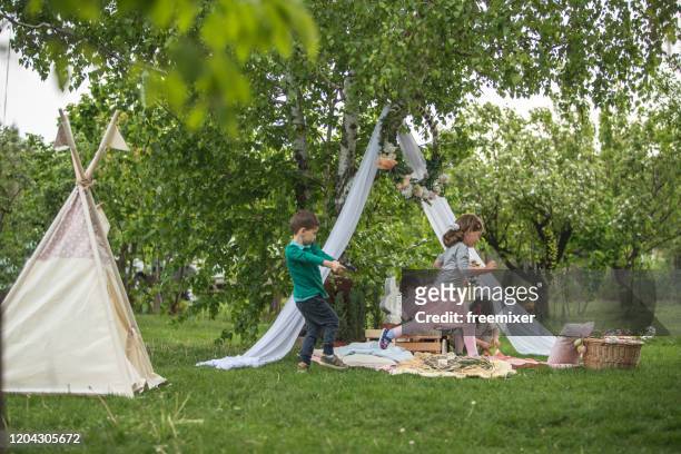 gruppe von kindern spielen im vorgarten auf ostereiersuche - easter garden stock-fotos und bilder
