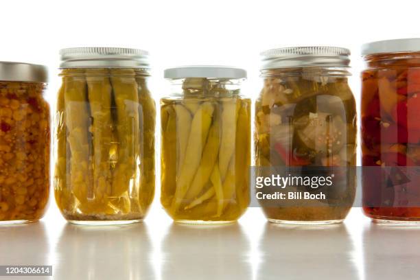 canning jars of different vegetables all in a row on a white background - mason jar stock pictures, royalty-free photos & images