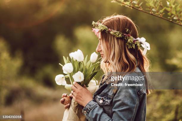 jonge vrouw die zich in aard met boeket van tulpen bevindt - bloemkroon stockfoto's en -beelden