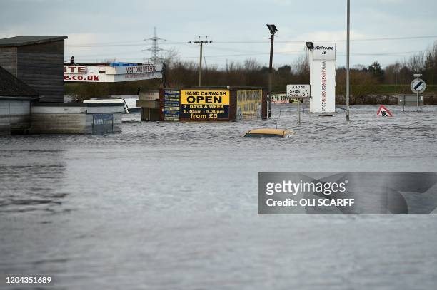 The roof of a car is barely visible as flood water covers roads and surrounds buildings in Snaith, northern England on March 1, 2020 after Storm...