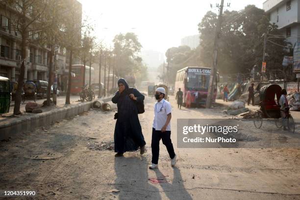 Children and her mother cross a dusty road in Dhaka, Bangladesh on Sunday, Mar. 01, 2020. Bangladeshs capital has topped the list of cities with...