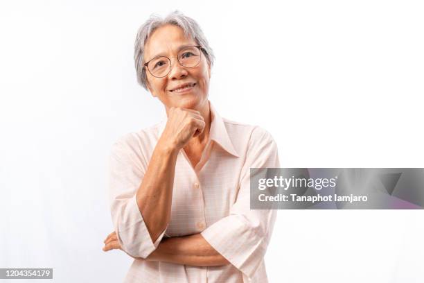 asian  senior woman smiling with hand touching chin studio shot isolated on white background - asian man studio shot stock pictures, royalty-free photos & images