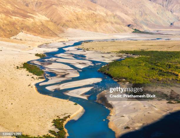 arial view of flowing river in valley of himalaya in ladakh - arial desert stock-fotos und bilder
