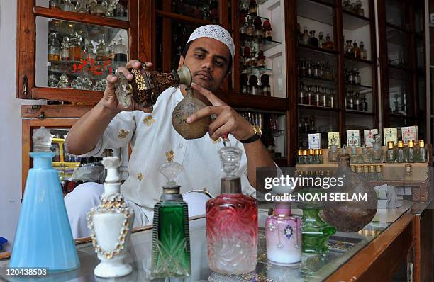 Mohammed Hashim, an Indian perfumer fills Mushk Amber, non-alcoholic perfumes locally called Attar, into traditional leather made containers at his...