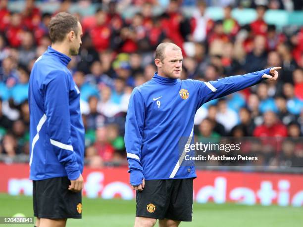 Dimitar Berbatov and Wayne Rooney of Manchester United in action during a first team open training session at Old Trafford on August 6, 2011 in...