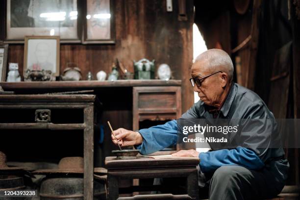 chinese senior man writing chinese calligraphy - chinese script stock pictures, royalty-free photos & images