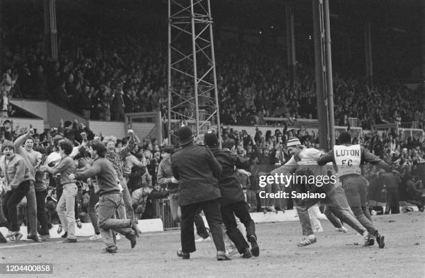 Police restrain football fans during a pitch invasion during the FA Cup Fifth Round replay between Luton Town and Watford at Kenilworth Road, Luton,...