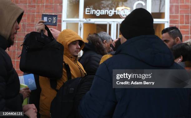 Man holds up a Libyan passport as he waits outside the Berlin Immigration Office , formerly known as the Ausländerbehörde , for assistance in...