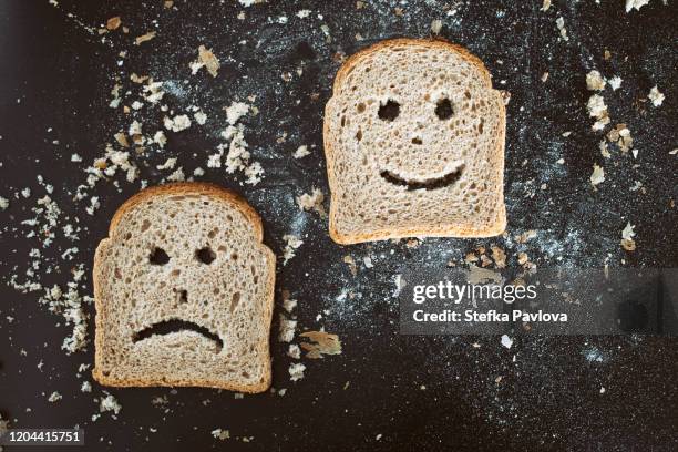 slices of bread toast with happy and sad human face representations - sans gluten photos et images de collection