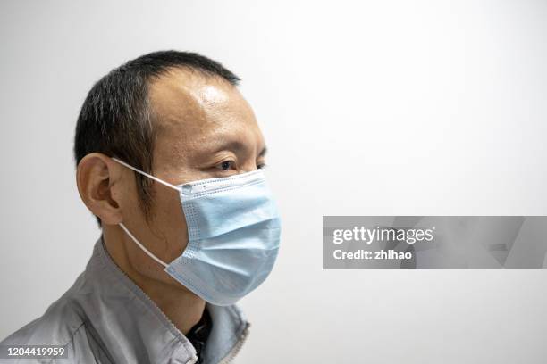 asian middle-aged man wearing protective mask - wearing mask side view stock pictures, royalty-free photos & images