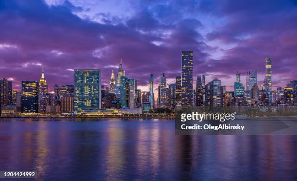 new york city skyline with un building, chrysler building, empire state building and east river at sunset. - new york skyline night stock pictures, royalty-free photos & images