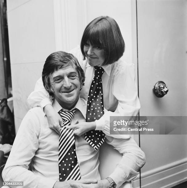English fashion designer and fashion icon Mary Quant, wearing polka dot necktie, adjusts a polka dot striped necktie on English broadcaster,...