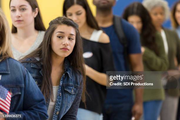woman in long line checks to see how much longer - impatient stock pictures, royalty-free photos & images
