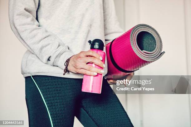 medium  shot mature woman with reusable water bottle and exercise mat - mat stock pictures, royalty-free photos & images