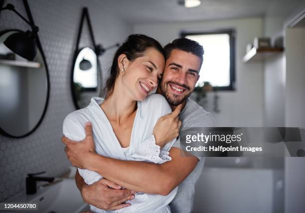 portrait of young affectionate couple standing indoors in bathroom at home. - bad relationship stock-fotos und bilder