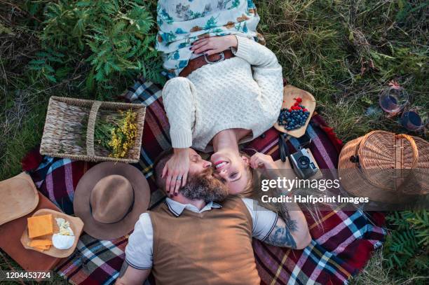 view from above of happy mature couple lying outdoors in autumn nature, having picnic. - romantic picnic stockfoto's en -beelden