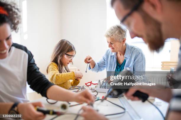 a group of people repairing household equipment in community center. - piccoli elettrodomestici foto e immagini stock