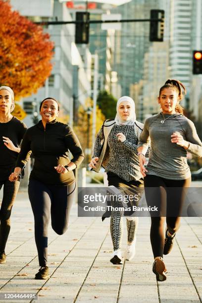 Female Muslim athletes running in city on fall afternoon