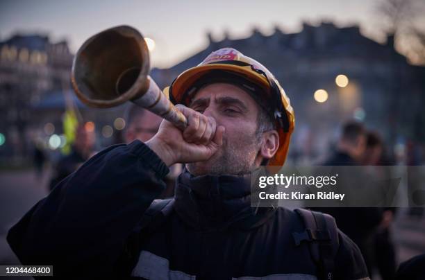 French railway CGT Union member blows a horn as thousands march through the streets of Paris on the 9th inter-professional day of strikes and...