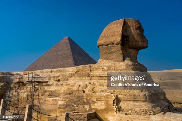 Sphinx with view of the Great Pyramids of Giza, Cairo, Egypt.